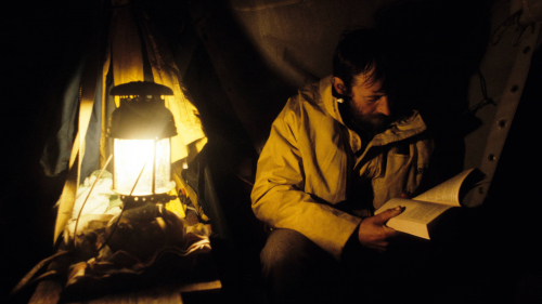 Tim reading by kerosene light