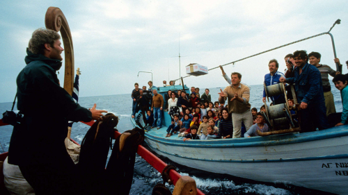 A greek fishing boat passes supplies